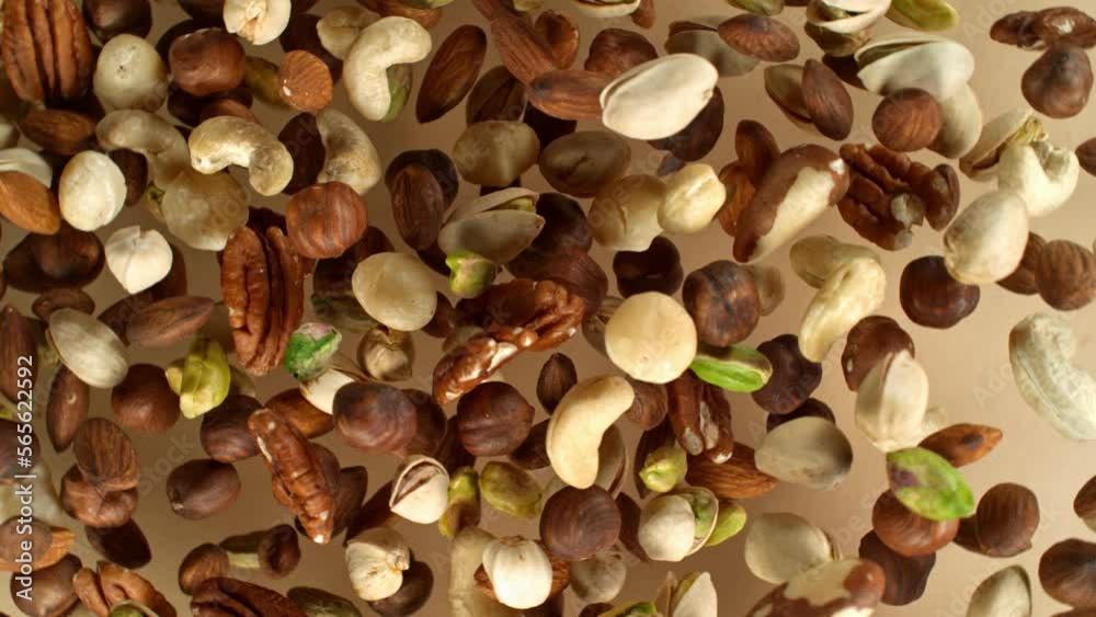 Poster super slow motion of rotating mix nuts up to the air. filmed on high speed cinema camera, 1000fps, p