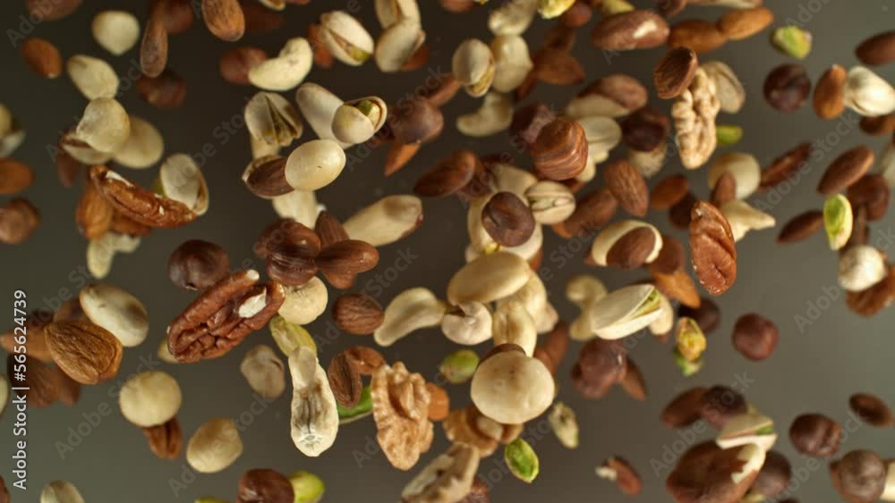 Poster super slow motion of rotating mix nuts up to the air. filmed on high speed cinema camera, 1000fps, p