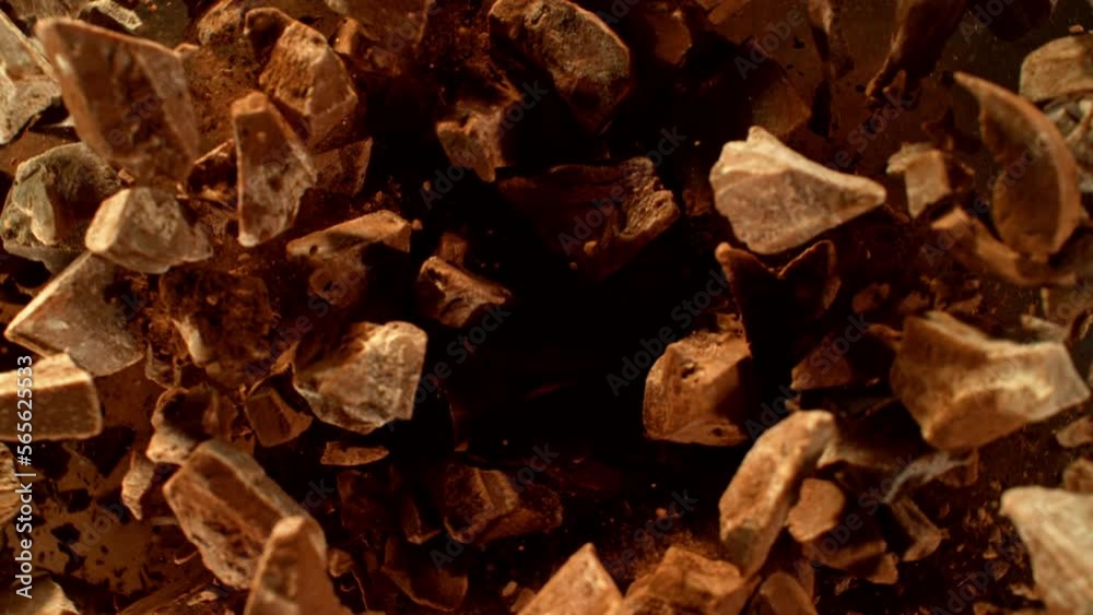 Poster super slow motion of rotating group of raw chocolate pieces. super fast camera motion. filmed on hig