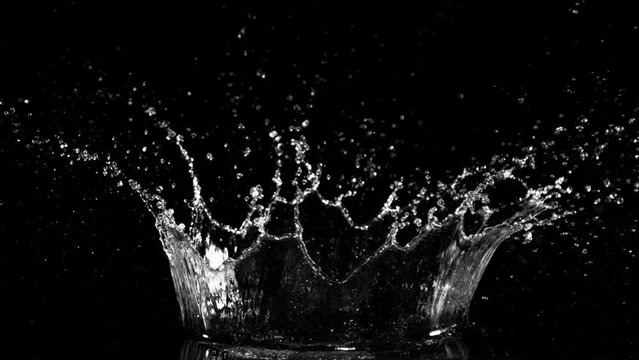 Super slow motion of splashing water crown shape on black background. Filmed on high speed cinema camera, 1000fps.