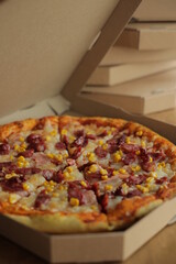 pizza with corn, mozzarella, sausage and meat. Pizza with boxes