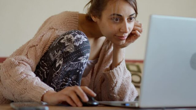 woman sits at home on couch with laptop, working remotely, shopping online. freelancer, remate work, workplace at home