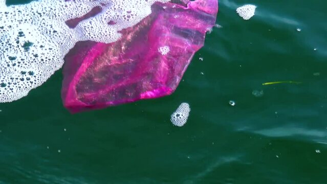 Garbage plastic bag on the sea beats with a wave, ecology