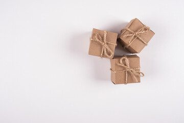 Brown gift boxes wrapped with kraft paper on white background. Top view of gift boxes tied with brown ribbon. Copy space