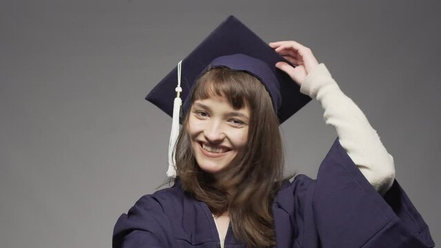 Graduation girl wearing cap and taking off  protective face mask. Female student smiling and throwing hat in the air.