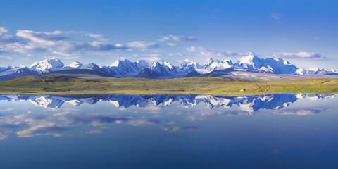 Kakshaal Too mountains reflecting in an alpine lake, Tian Shan mountain range near the Chinese border, Naryn Region, Kyrgyzstan - obrazy, fototapety, plakaty