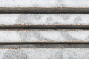 Wooden bench covered with snow