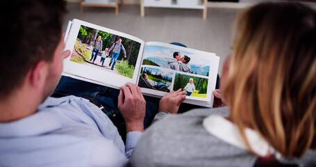 Couple Family Looking Photo Album - obrazy, fototapety, plakaty
