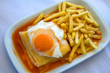 Bandeja con francesinha portuguesa con patatas fritas