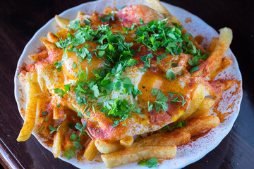 Patatas con salsa y huevos fritos