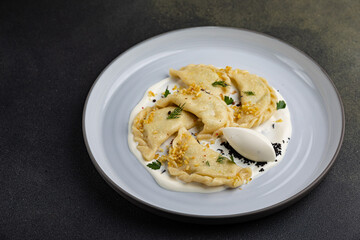 delicious Ukrainian dumplings with sauce on a plate.
