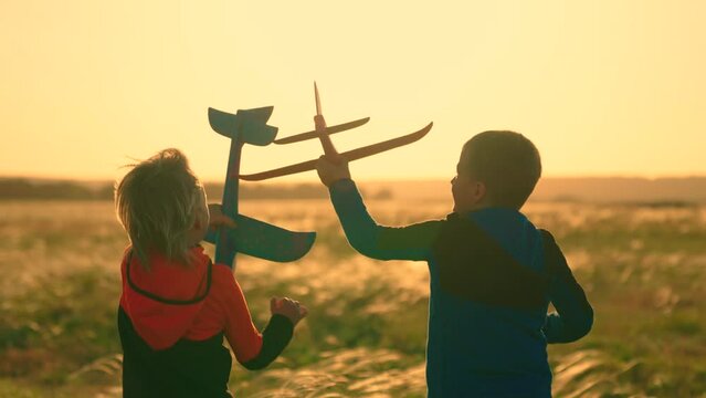 Children boy play with toy airplane outdoors. Child pilot runs with toy plane across field against sky. Child wants to become an astronaut. Teenage dreams of flying becoming pilot. Future kid concept