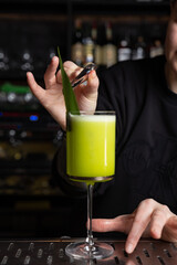 the bartender prepares a delicious alcoholic cocktail	