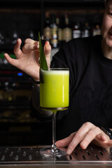 the bartender prepares a delicious alcoholic cocktail	