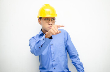 asian male construction worker or engineer in blue shirt and safety yellow helmet shows expresion of anger, furious and dissapointment isolated over white. stressed over work concept