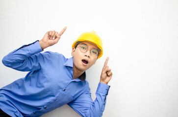 asian construction worker wearing yellow safety helmet and smiling and pointing finger with happy and shocked expression. billboard model advertisment concept. construction worker presenting something