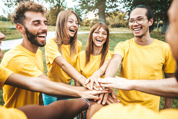 Multi ethnic young people team stacking hands together outside - International university students...