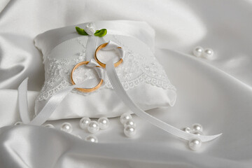 Wedding rings on the pillow.