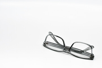 Pair of glasses with grey frames on a plain white background. Copy space. No people.