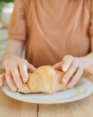 woman cooks drinks and eats croissant in morning for breakfast, brew a drip or purover. americano cappuccino. food and drink for lunch, happy woman eats and enjoys. lifestyle, concept of free life