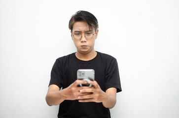 Young Asian man with peek-a-boo hair, sad and dissatisfied, holding phone and receiving bad news.