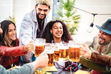 Young happy friends drinking and toasting beer at brewery bar - Food and beverage life style concept with guy and girls having fun together out side at restaurant garden patio - Bright vivid filter