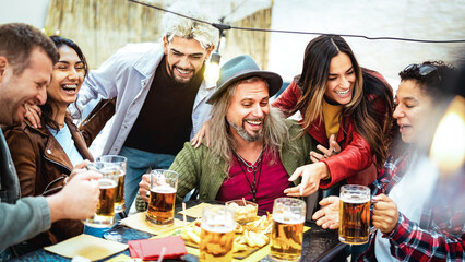 Happy mixed age people drinking and toasting beer at brewery bar restaurant - Beverage life style concept with men and women friends having fun together out side at garden patio - Bright vivid filter