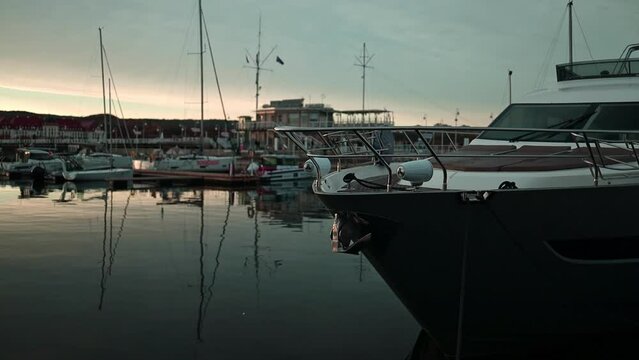 View of boats and luxure yachts in dock at sunset on a calm lake in summer in Sopot, Poland. Colorful landscape with sailboats and motorboats in sea. 