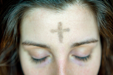 woman with cross on forehead in observance of Ash Wednesday - obrazy, fototapety, plakaty