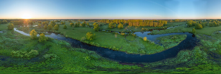 Forest in summer colors. Green deciduous trees and winding blue river in sunset. Soomaa wooded meadow, Estonia, Europe
