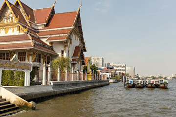 Obraz premium Traditional Thai temple and the boats on Chao Praya river in Bangkok Thailand 