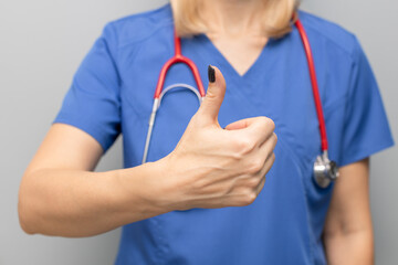 doctor in uniform in hospital holding thumb up
