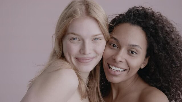 Closeup portrait of two young beautiful smiling hipster female in trendy summer clothes.Sexy carefree women posing on street background. Positive models having fun and hugging. High quality 4k footage