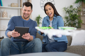 young couple playing with a small quadrocopter drone