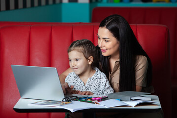 Mother helping her daughter with homework. Mother helping her daughter with homework. Happy childhood