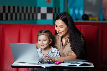 Mother helping her daughter with homework. Mother helping her daughter with homework. Happy childhood