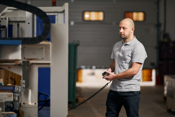 A young man stands in a furniture shop near the machine