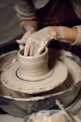 Closeup of potter's hands making clay water pot on pottery wheel. Clay pots are used since ancient times and can be found in Indian subcontinent.