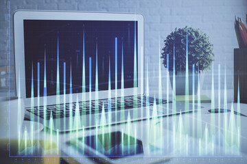 Stock market graph on background with desk and personal computer. Multi exposure. Concept of financial analysis.