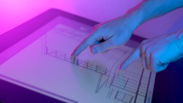 architect uses tablet computer and draws project of building
