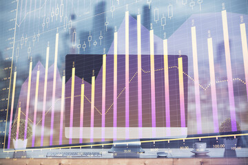 Stock market graph on background with desk and personal computer. Multi exposure. Concept of financial analysis.
