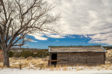 A Forgotten Cabin Amidst the Snow on a Cloudy Day