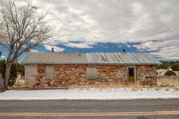 A Forgotten Cabin Amidst the Snow on a Cloudy Day