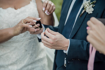 Obraz na płótnie Canvas A closeup shot of a groom gifting a golden bracelet to his bride during the wedding