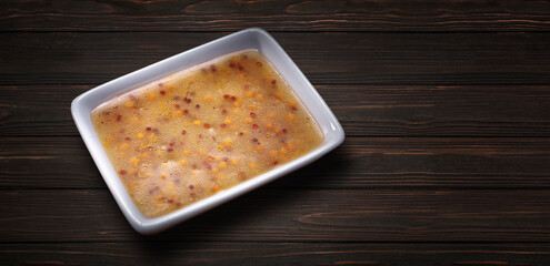 Dijon spicy mustard sauce in a white saucer