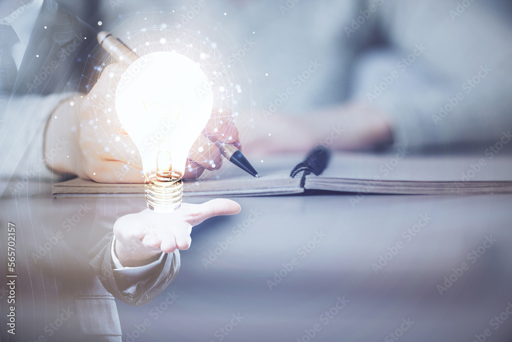 Poster bulb hologram over hands taking notes background. concept of idea. double exposure