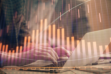 Double exposure of stock market chart with man working on computer on background. Concept of financial analysis.