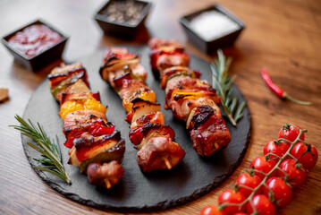 Meat kebabs with grilled vegetables on a rustic background