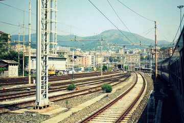 The view of the raildroad station against the background of the green mountains and the sky.