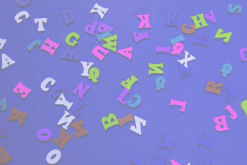 Random colorful alphabet on a red background, colorful letters.